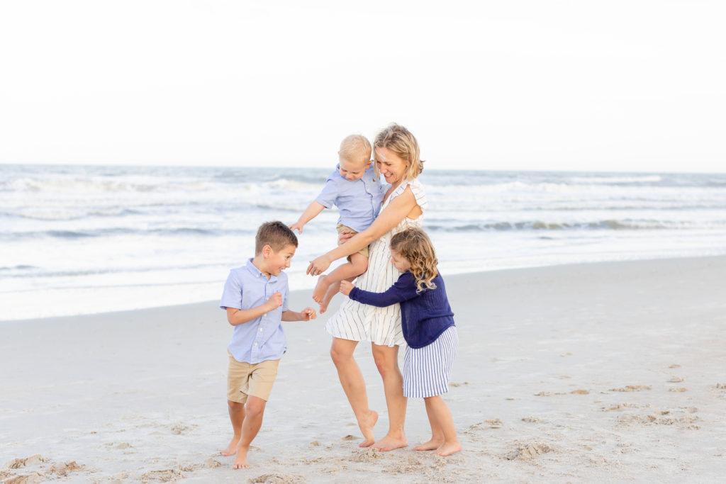 young mom playing with her three children on a jacksonville beach at a family photography session