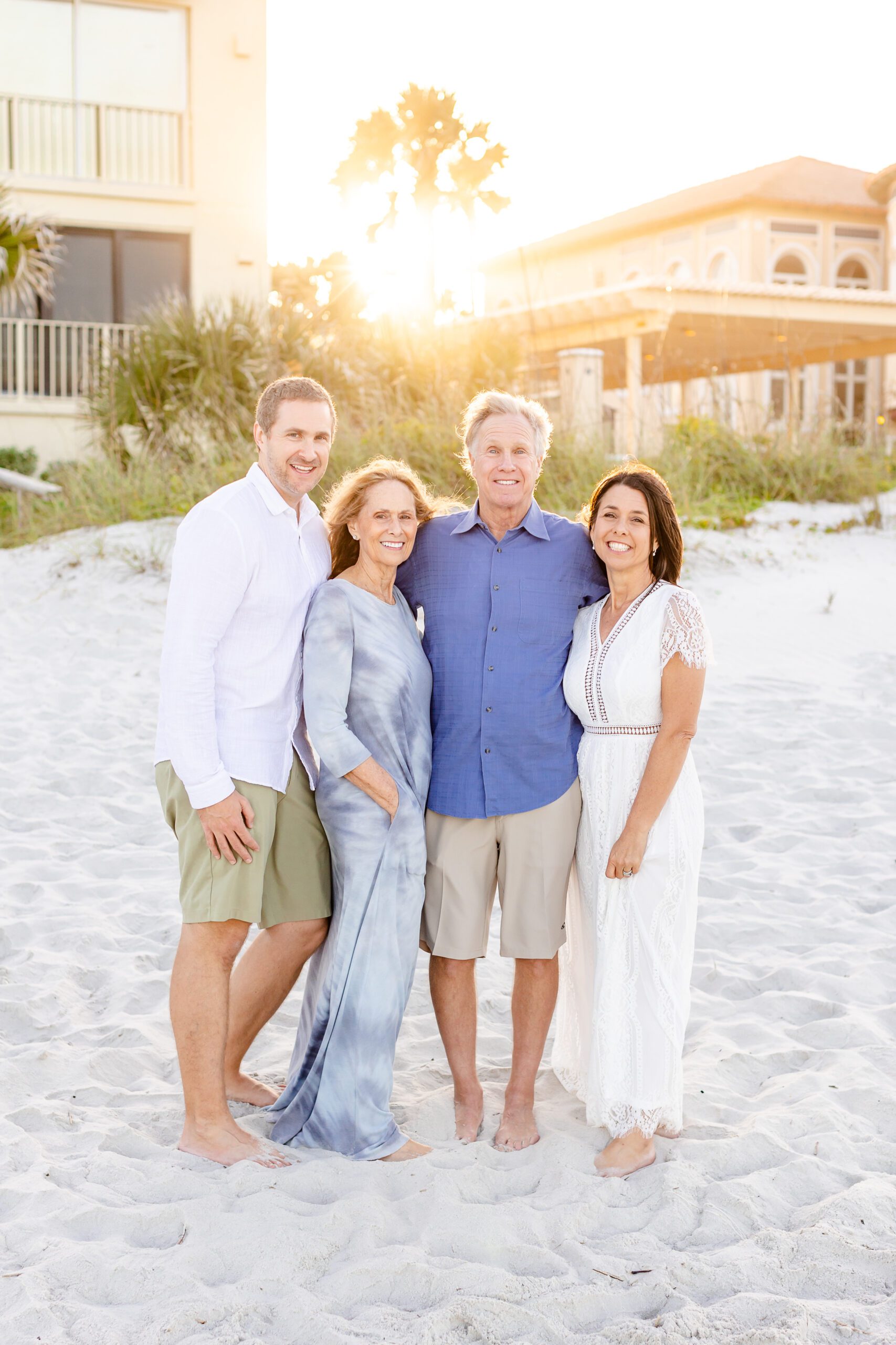 a family stands together on a beach looking at the camera during a model call family session